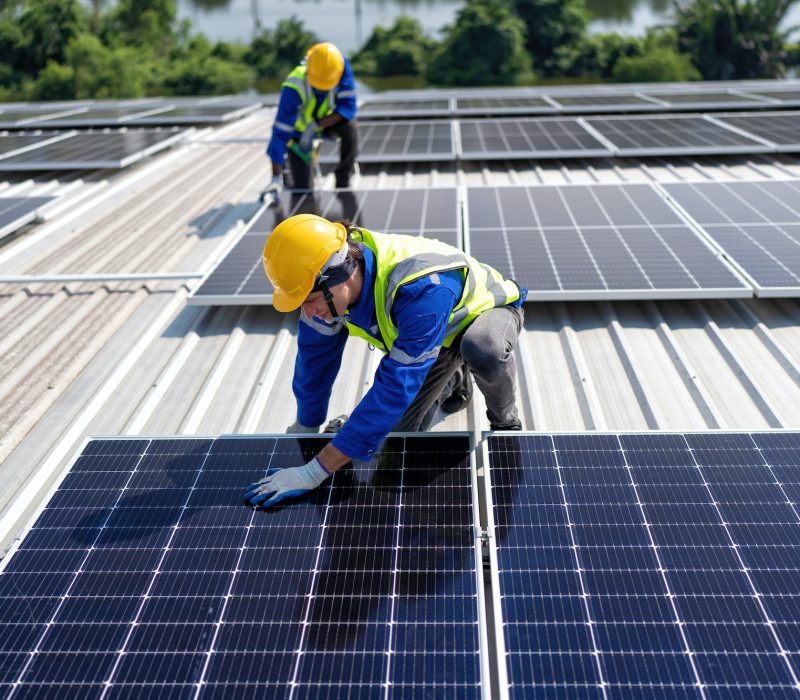 engineer-on-rooftop-kneeling-next-to-solar-panels-photo-voltaic-with-tool-in-hand-for-installation.jpg